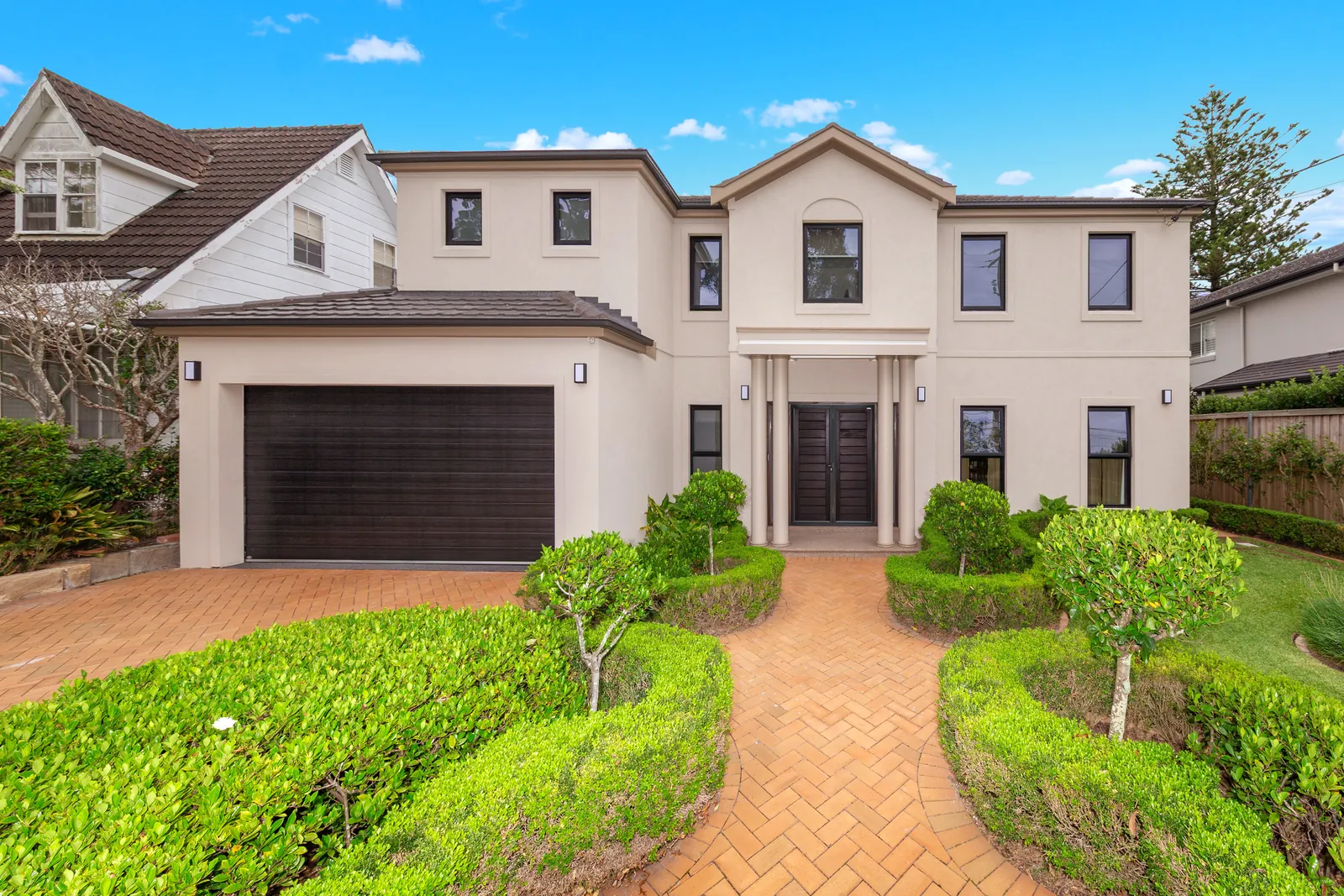 Front of a Walter Homes project in East Lindfield, with a brick-paved path and hedged garden
